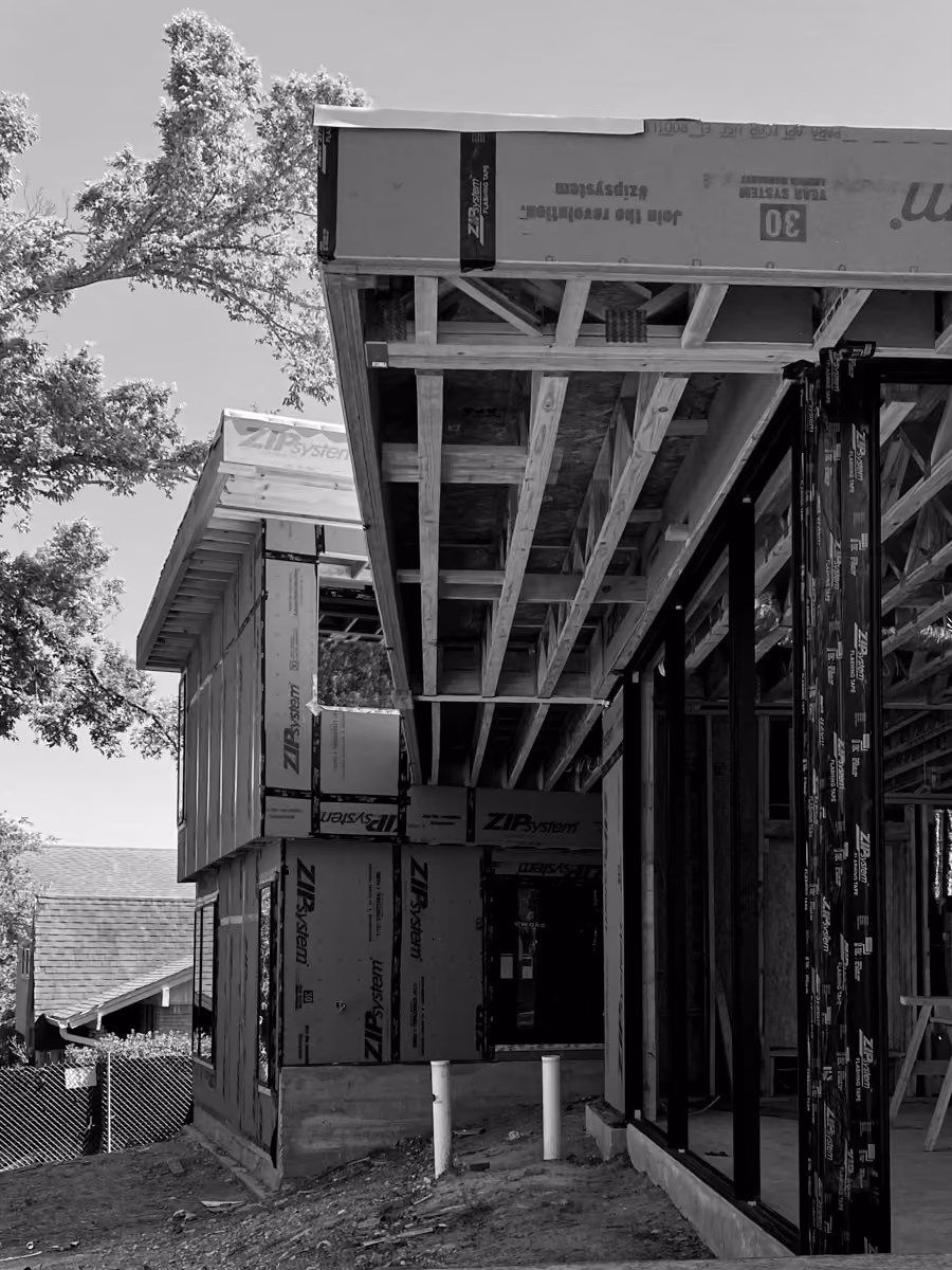 House under construction showcasing modern ZIP system framing and exposed wooden beams design.
