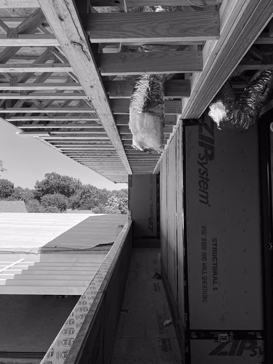 Exterior construction site showcasing wooden beams and innovative Zip System structural sheathing technology.