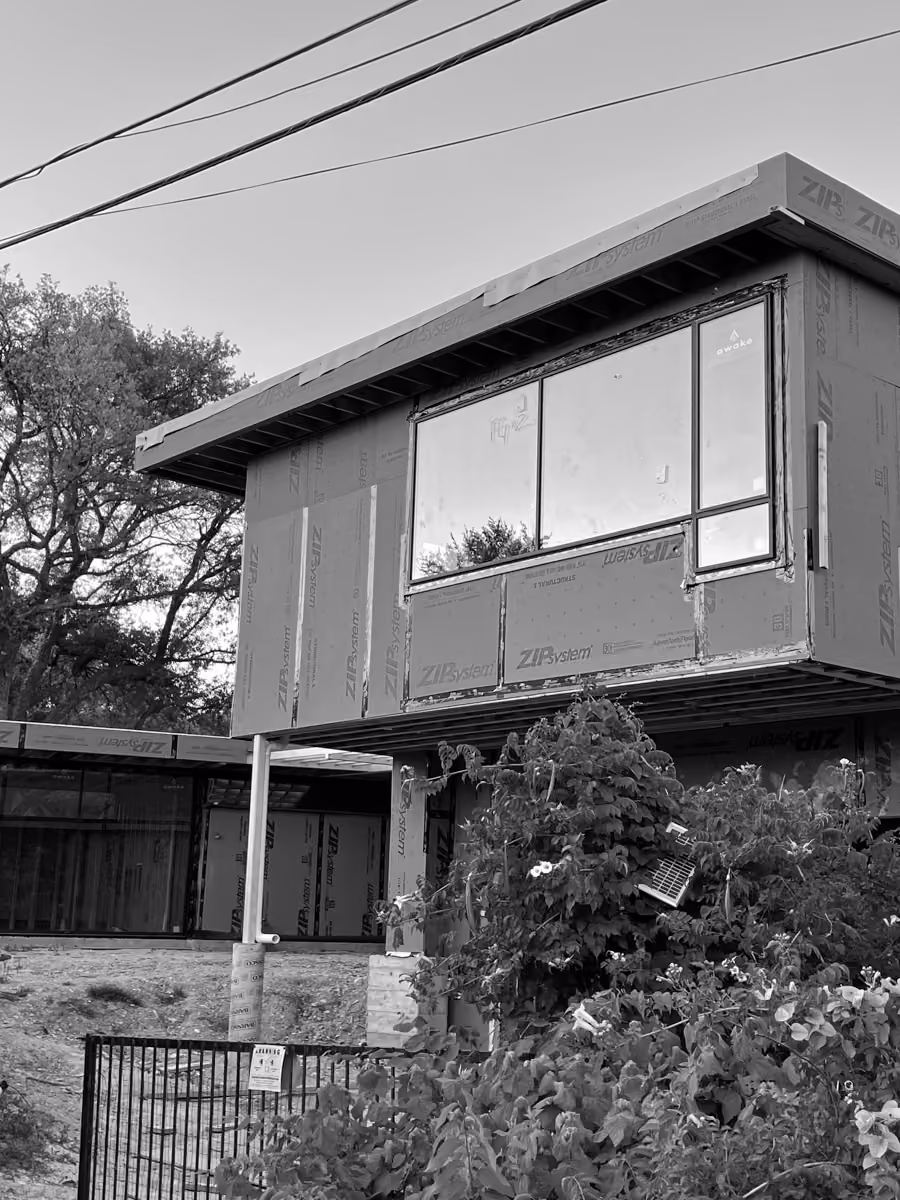 New home under construction with advanced zip system sheathing and large windows installed.