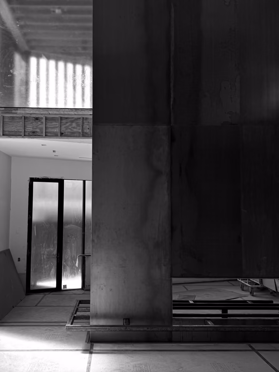 Modern industrial decor featuring a concrete pillar and floor-to-ceiling glass doors showroom setting.