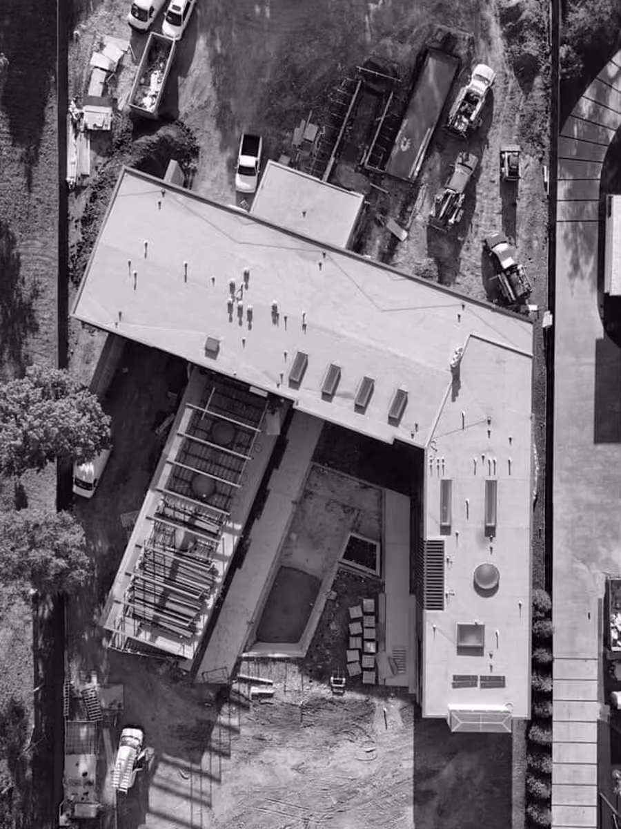 Aerial construction site photo with building, vehicles, and workers in the process.