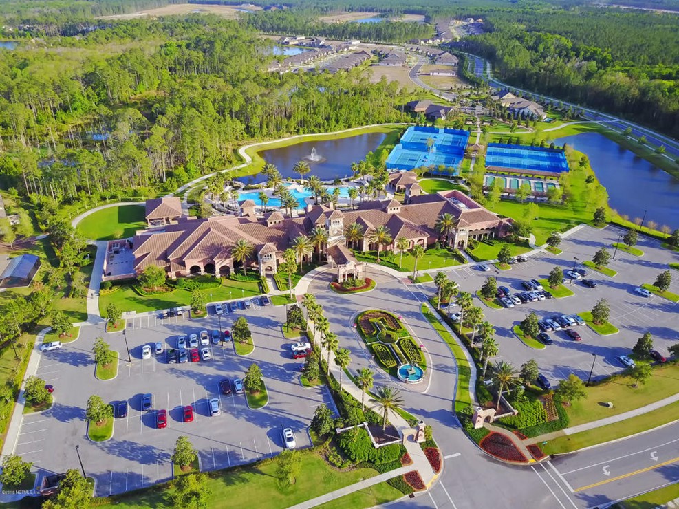 Aerial view of a resort with swimming pools, tennis courts, and lush landscaping