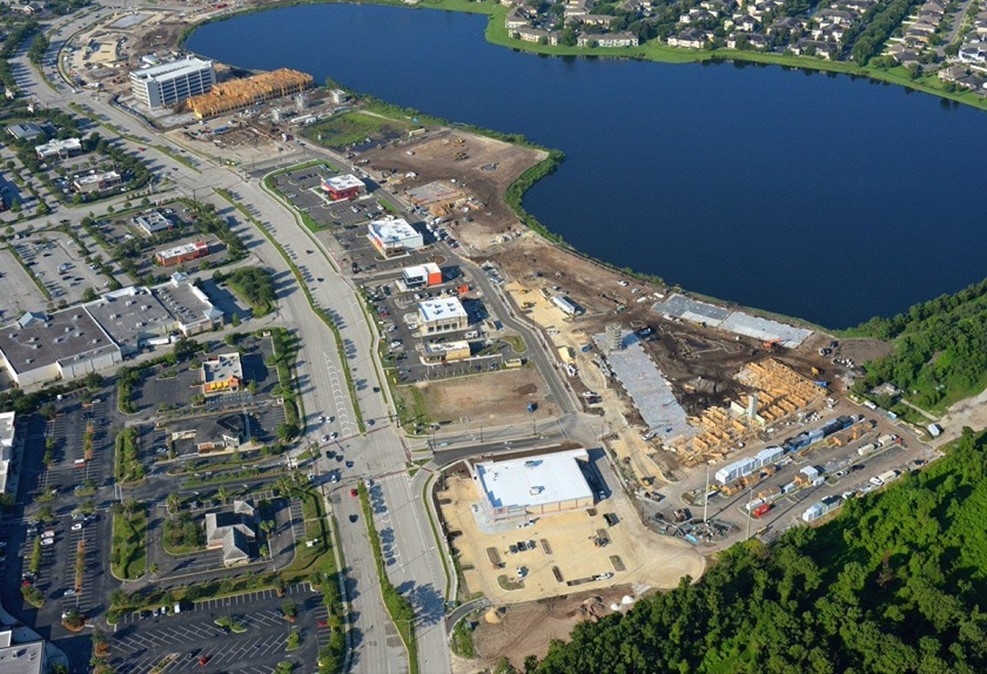 Aerial view of urban development near lake with construction and roads