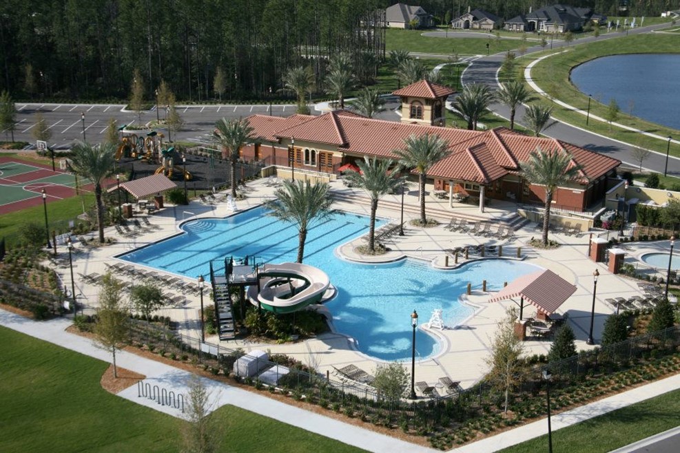 Aerial view of a community pool with water slides and palm trees