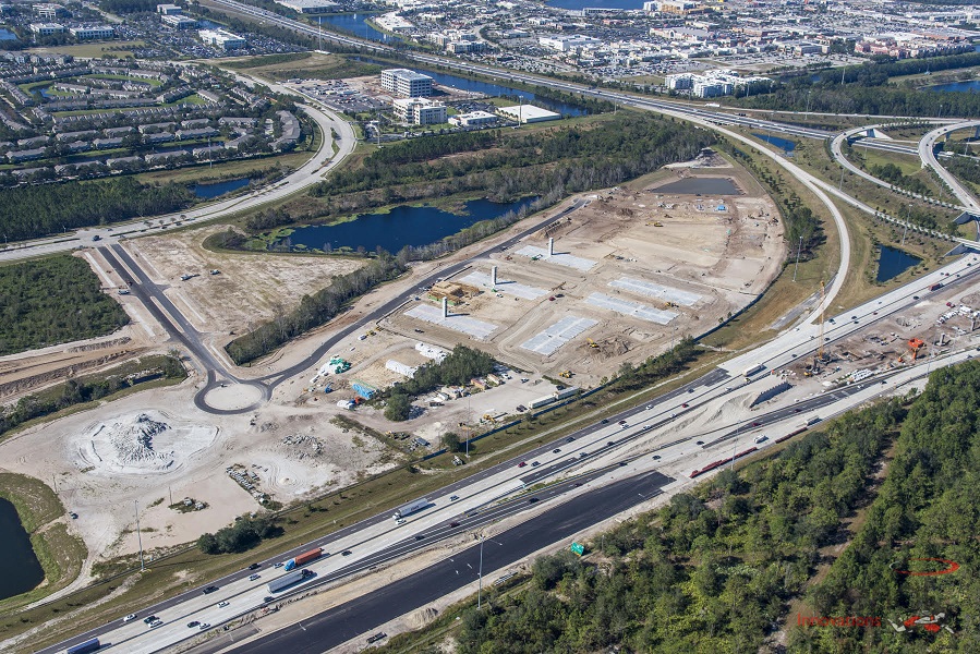 Aerial view of highway interchange and construction site with urban landscape