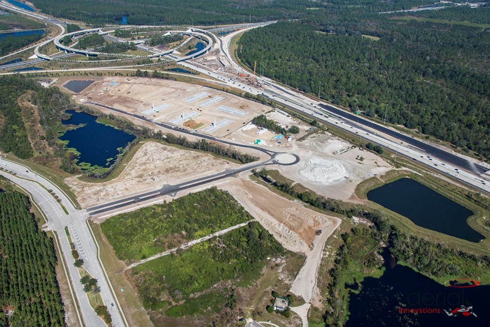 Aerial view of highway interchange with construction site and surrounding forest