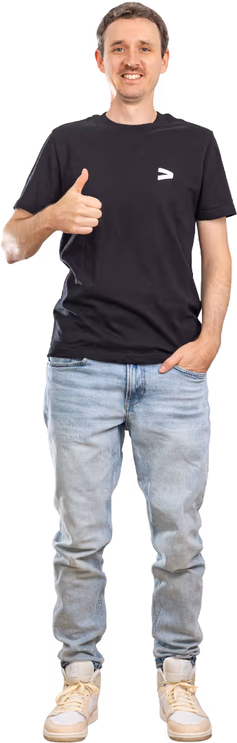 Der stehende junger Mann, Dominik Hutter, im schwarzen T-Shirt und hellblauen Jeans, gibt einen Daumen hoch.