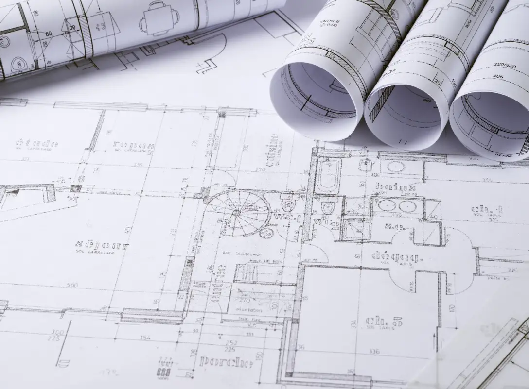 Architectural blueprints with detailed floor plans and rolled-up construction drawings on a white background