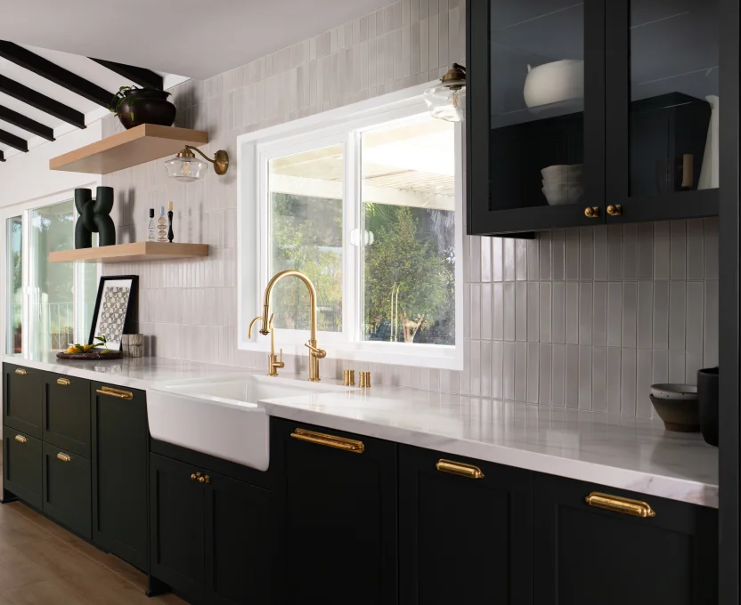 Stylish kitchen with farmhouse sink gold fixtures dark cabinets and open shelving
