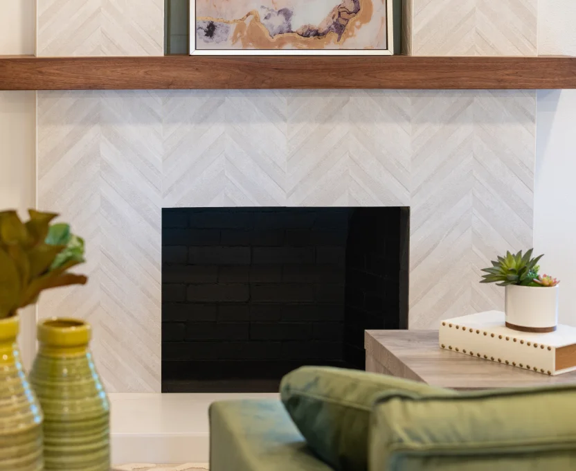 Modern fireplace with light herringbone tile wood mantel and decorative accents