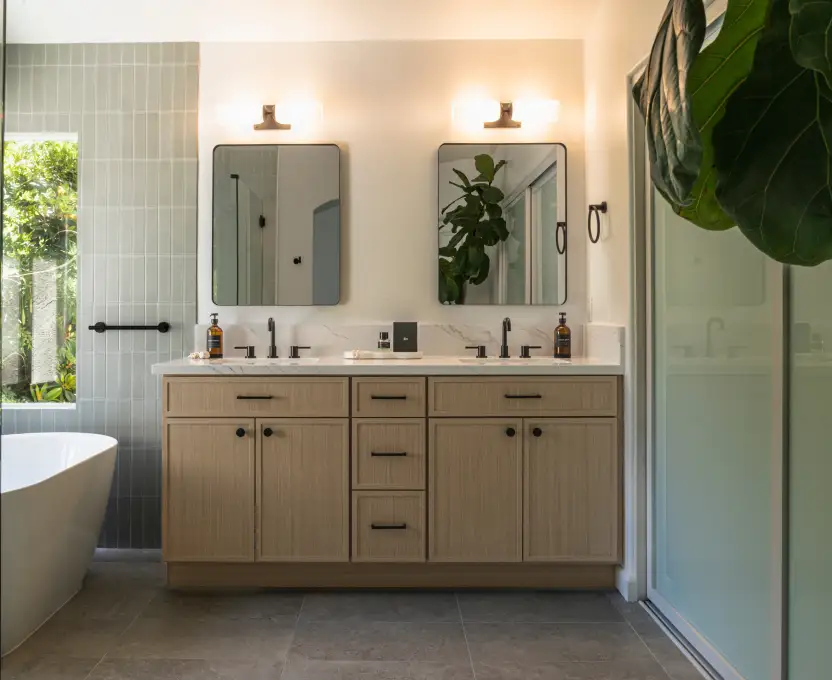 Modern bathroom with double vanity wood cabinets wall mirrors and natural light