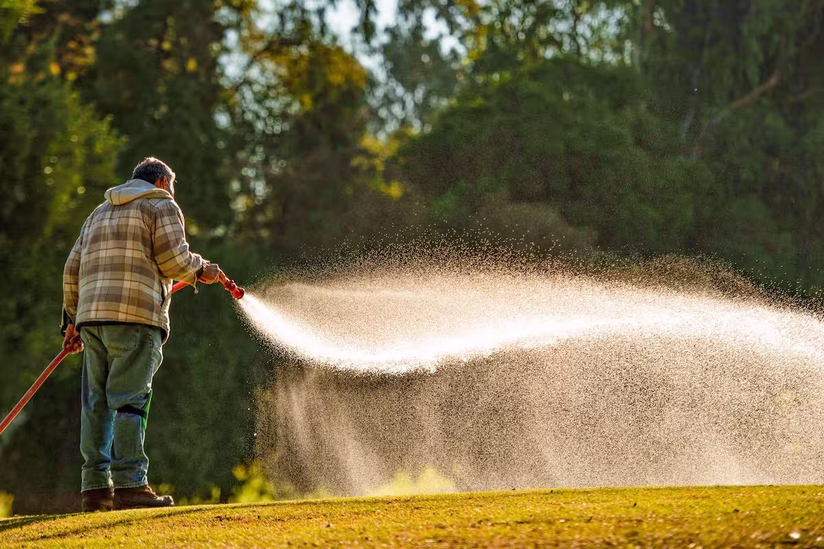 A golf course superintendent syringes a putting green to manage turf stress — SubAir Systems explores the science behind syringing, its varying definitions, methods, and the real impact on green health.