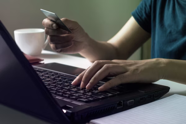 man making a cnp payment on a laptop