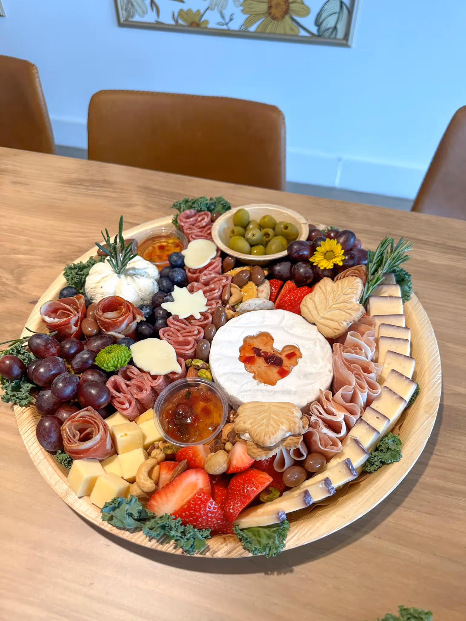 charcuterie board with cheese, ham, fruits, salami, olives, jam, chocolate, and nuts