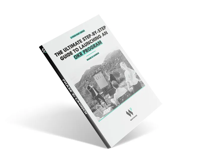 An angled view of the Wavenine ebook cover for "Phase 2: Launch," part of the four-part series on how to launch a successful OKR program.
