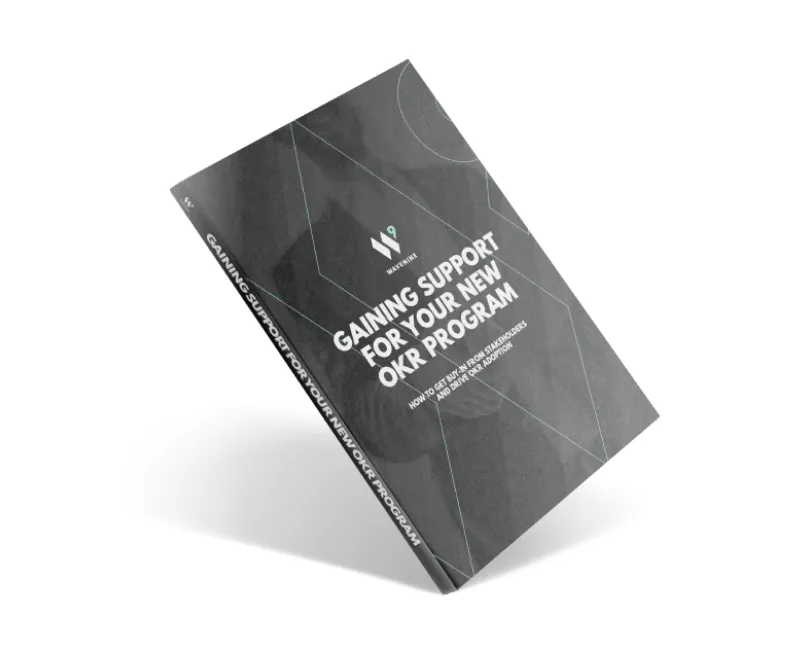 An angled view of the professional cover for the Wavenine ebook, "Gaining Support for Your New OKR Program." The dark cover with a geometric design highlights the guide's focus on stakeholder management and successful OKR implementation.