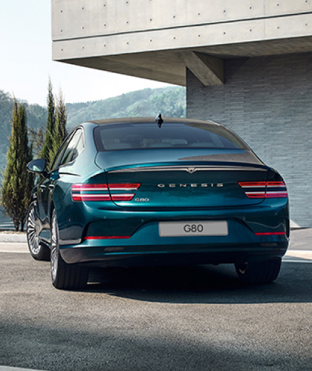 Blue Genesis Electrified G80 parked at a home