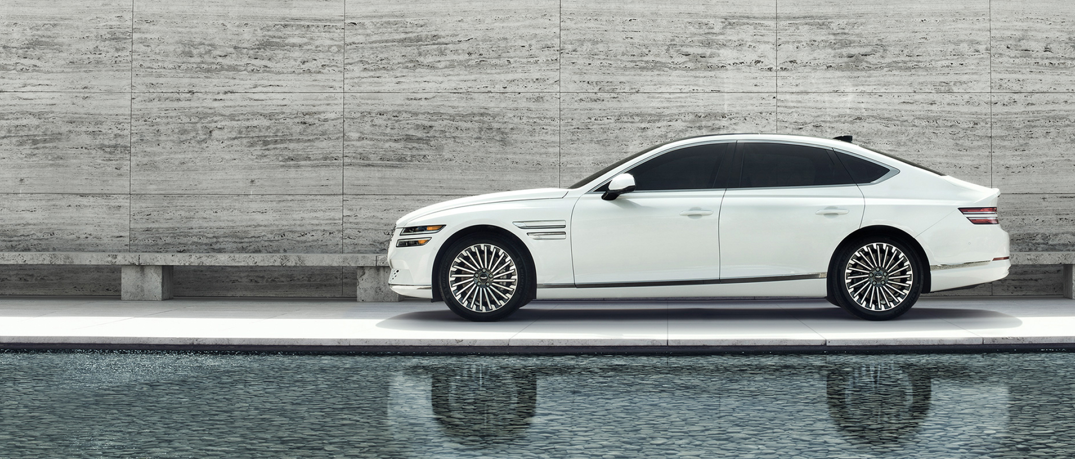 Side view of white Electrified G80 parked 