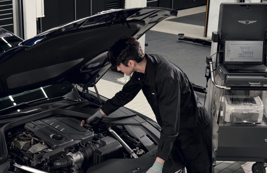 Man working on Genesis engine bay