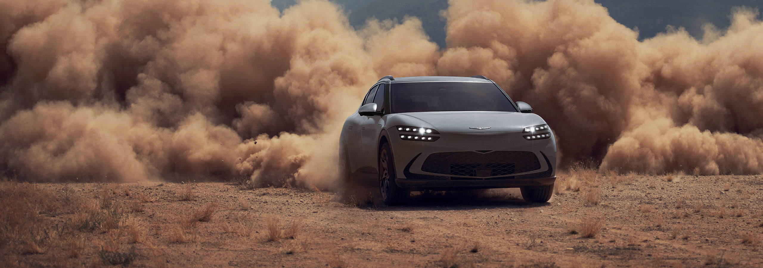 Front 3/4 view of GV60 driving on dirt terrain