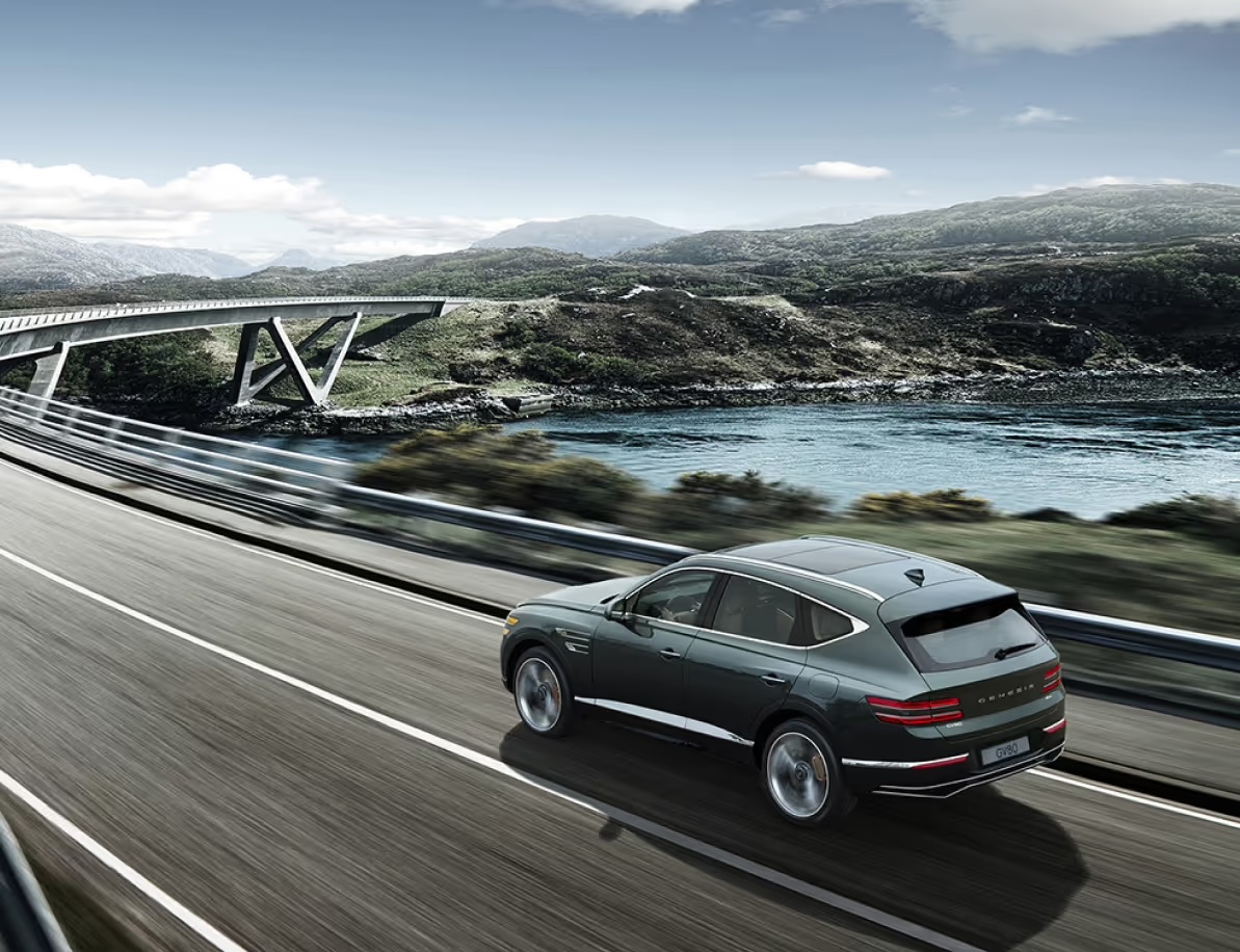 Storr Green GV80 driving fast on the highway while maintaining a safe distance from the vehicle in front.