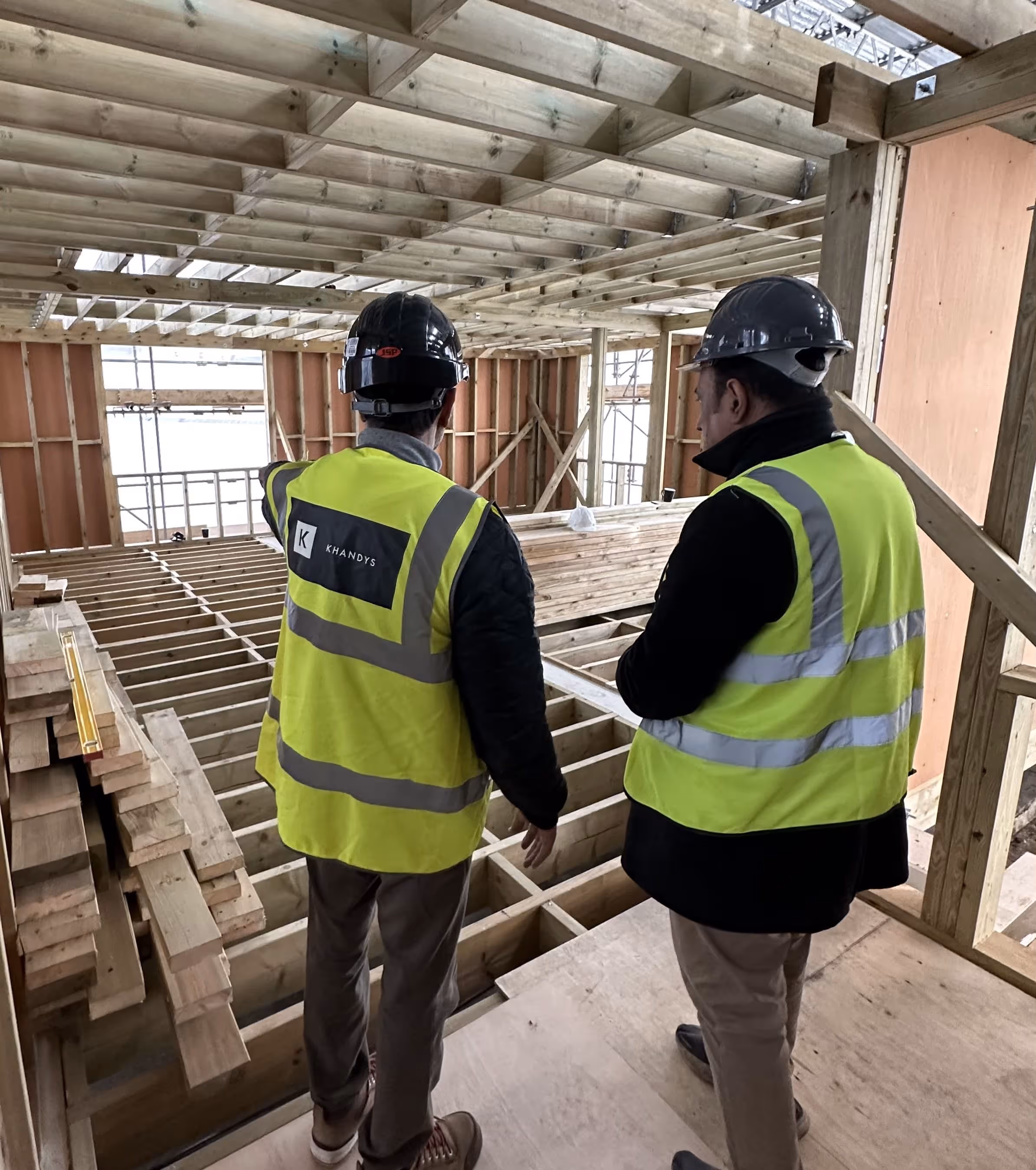 Photo showing two workers wearing the Khandys logo on their high visibility vests
