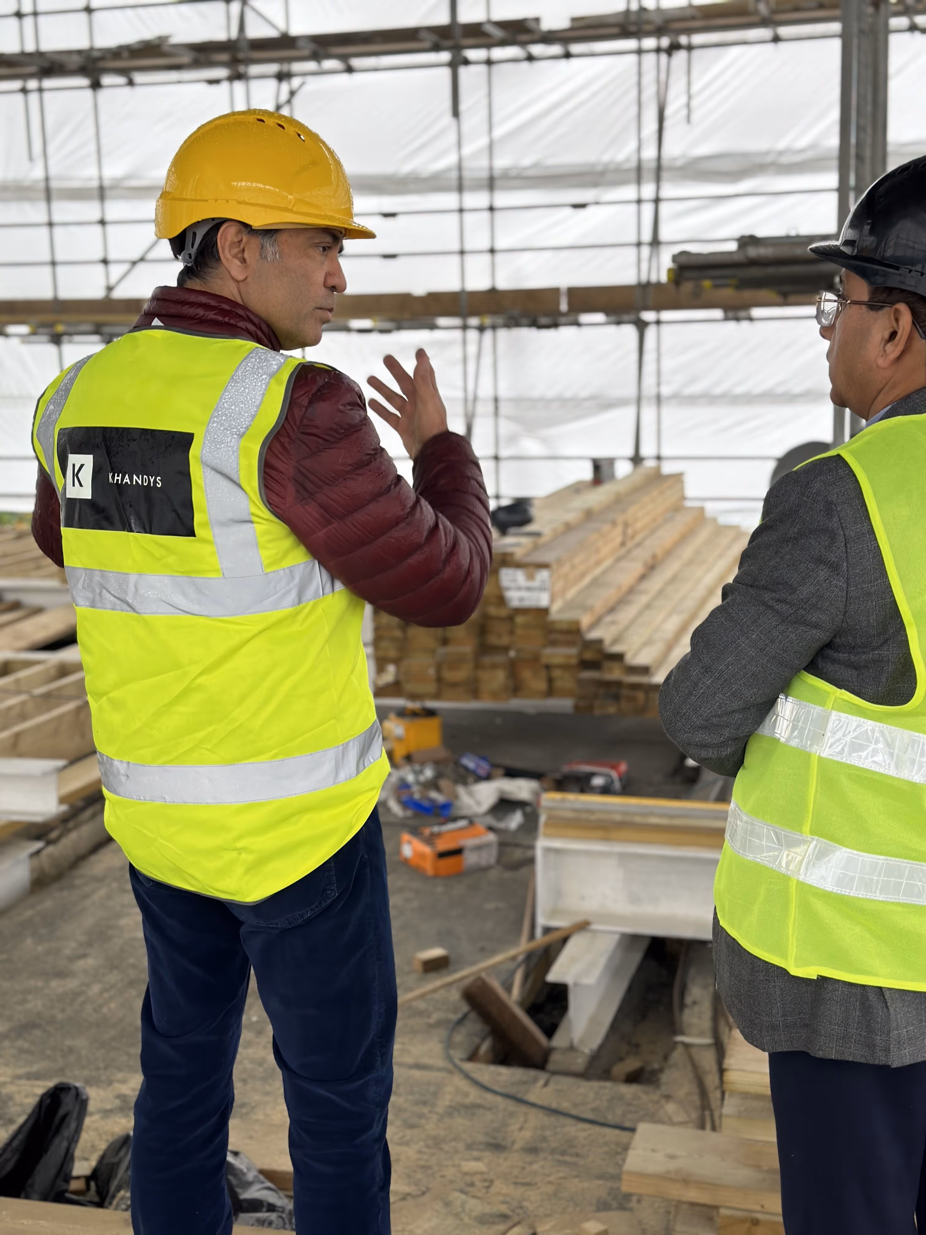 Photo showing two contractors talking wearing a Khandys hi-vis vest