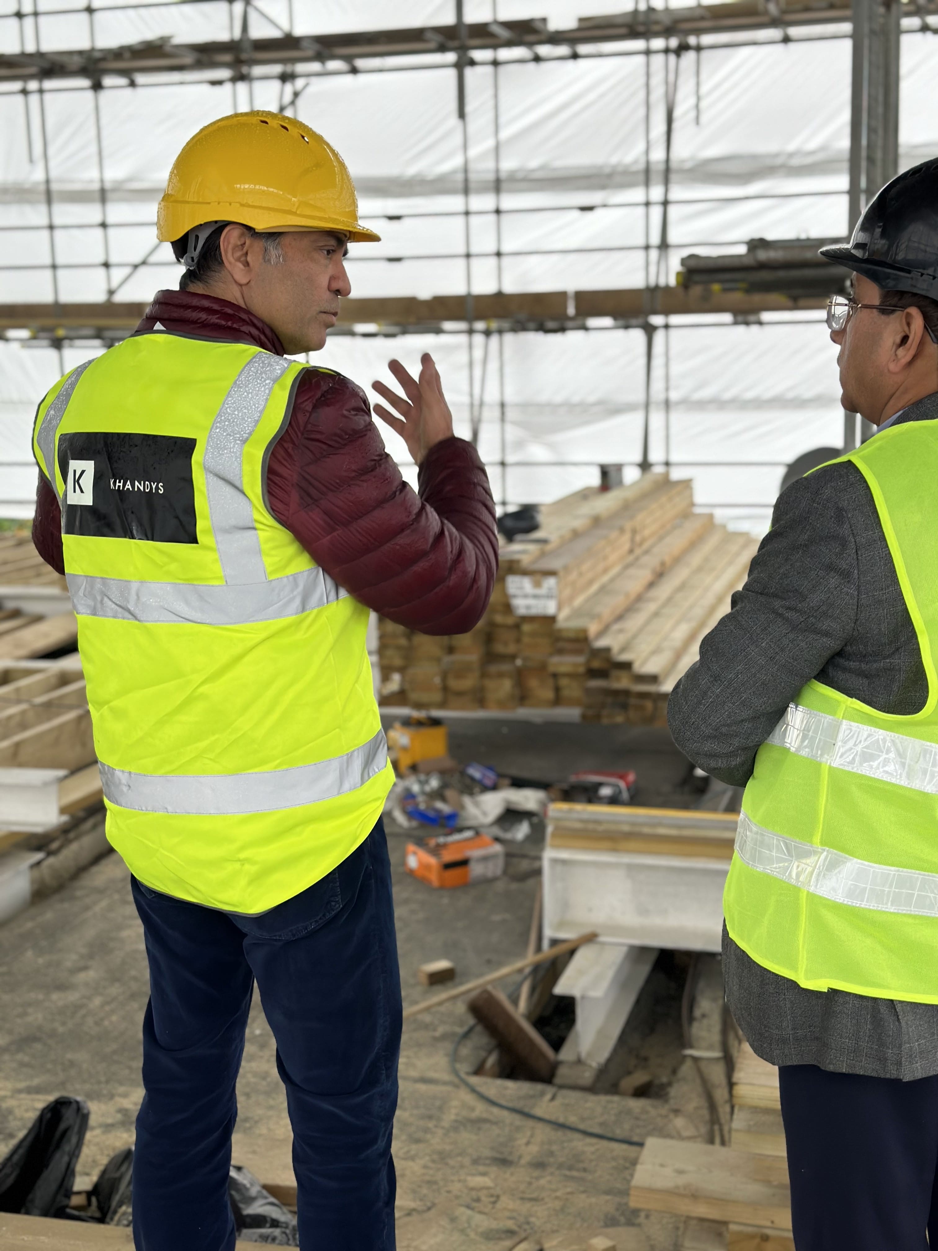 Photo showing two contractors talking wearing a Khandys hi-vis vest
