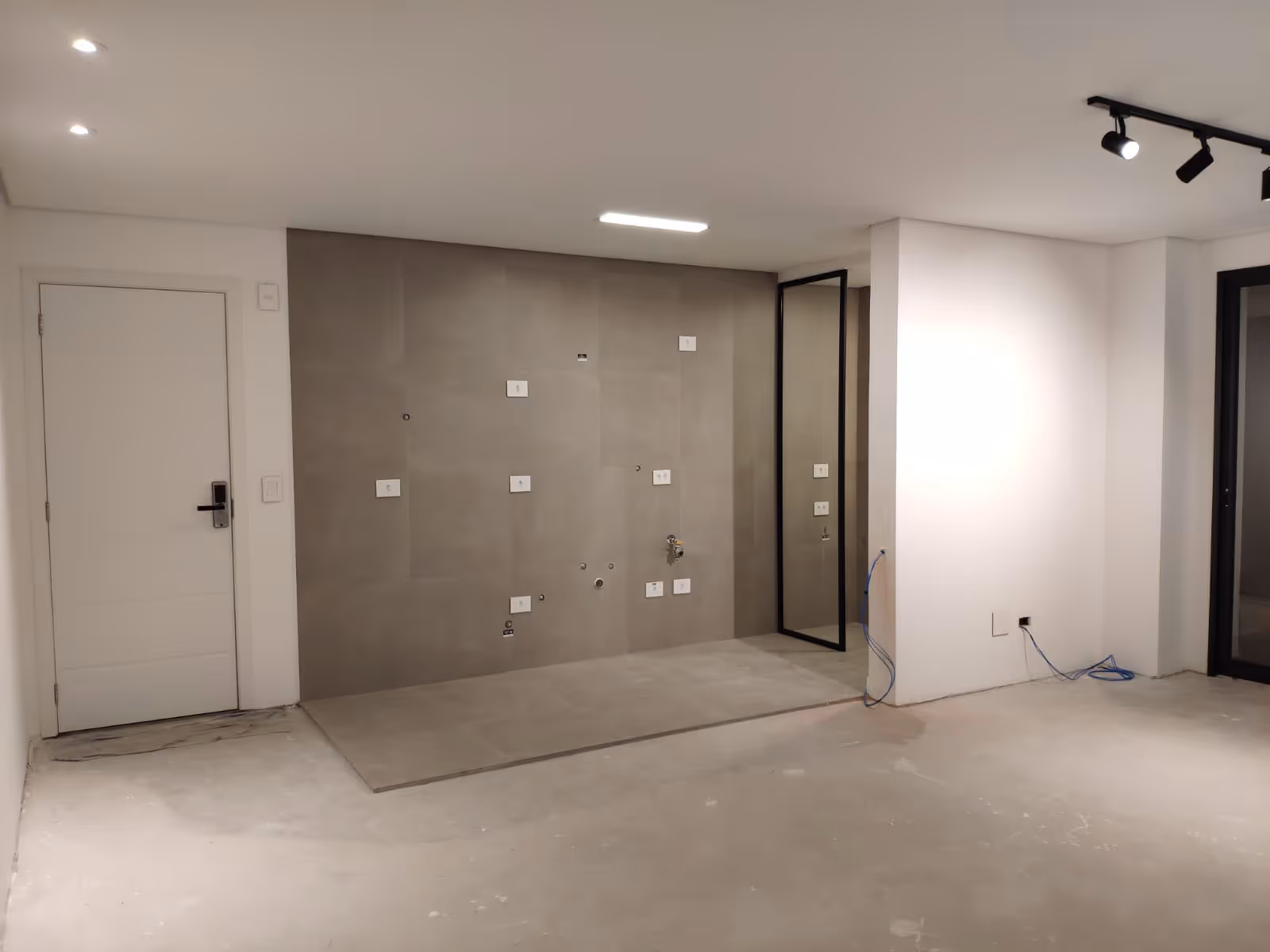 Ambiente vazio com pontos para eletros e pia, com forro e iluminação já instalados