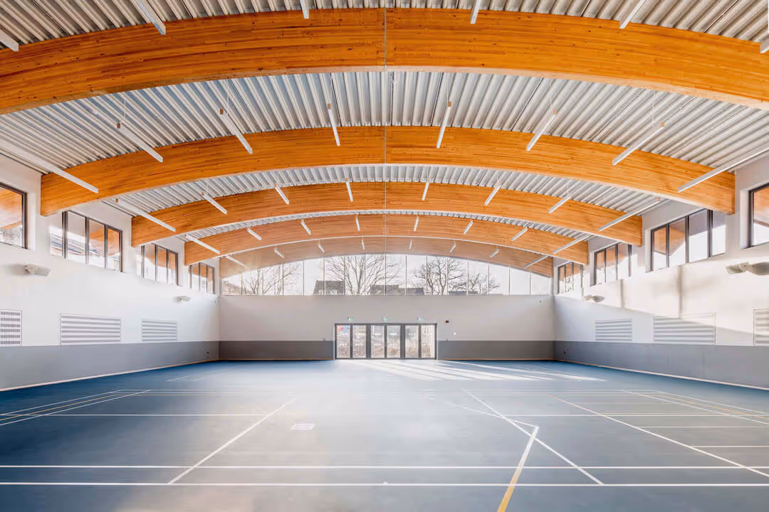 An interior of a large empty sports hall. Part of the YMCA architecture project