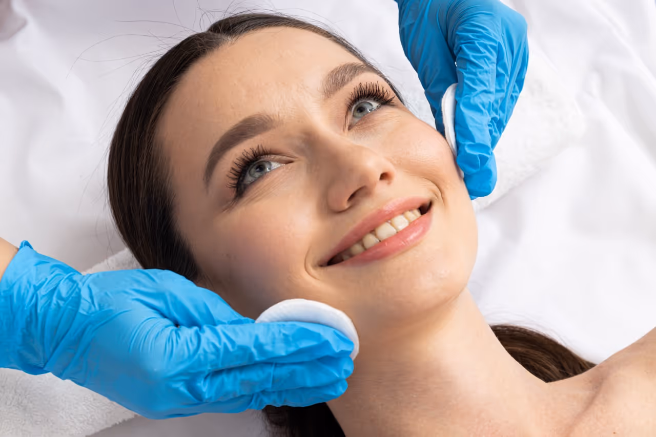 Woman smiling while receiving dermilogical treatment