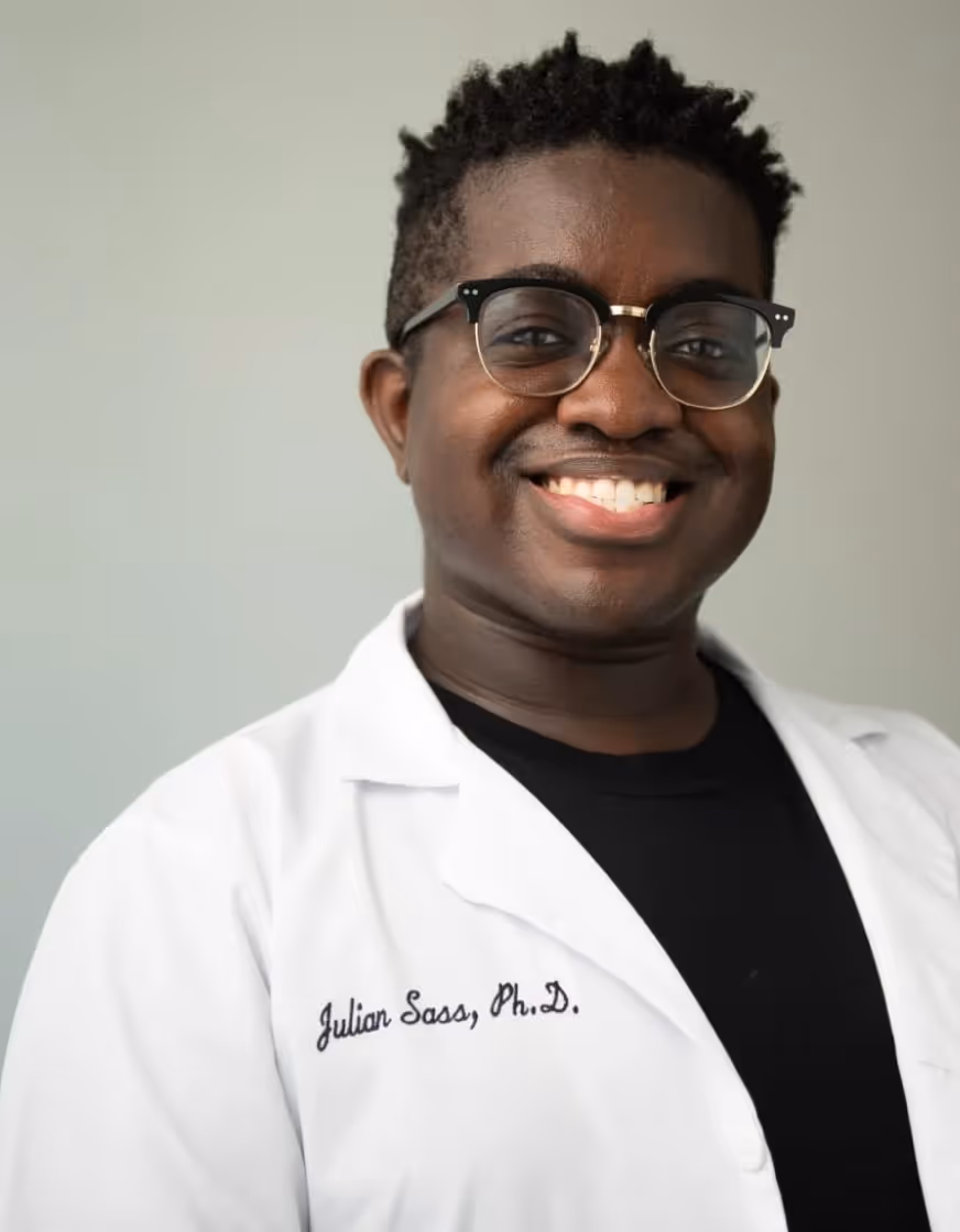 Professional head shot of Dr. Julian Sass with a friendly smile. Dr. Julian Sass is a cosmetic scientist and a skincare educator working in Montreal. He is Afro American, and is currently based in Canada.