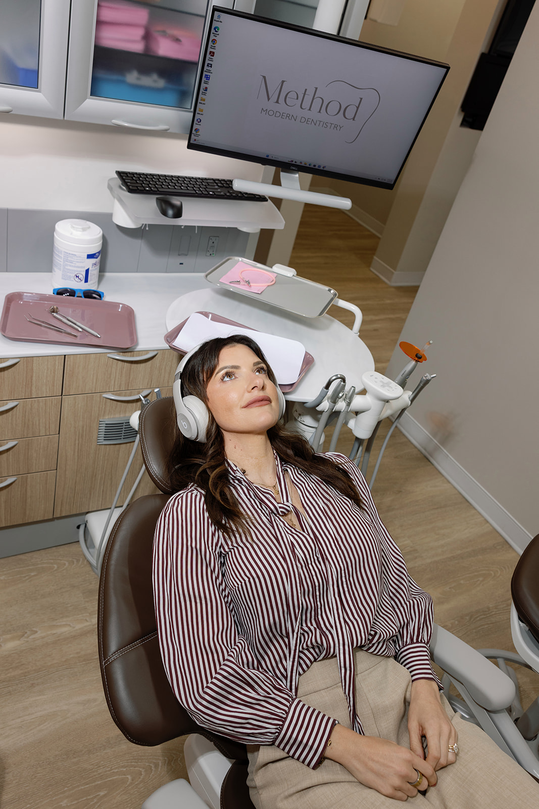 Patient relaxes with headphones in a treatment chair at Method Modern Dentistry.