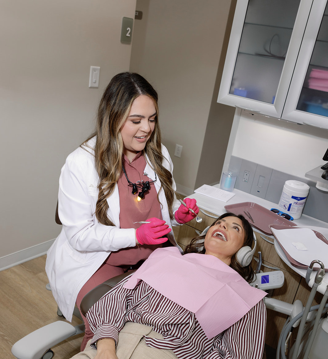 Dentist examining a patient’s teeth during a comfortable dental visit in a modern treatment room.