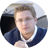 A man with glasses and a blue sweater. - Forme Images