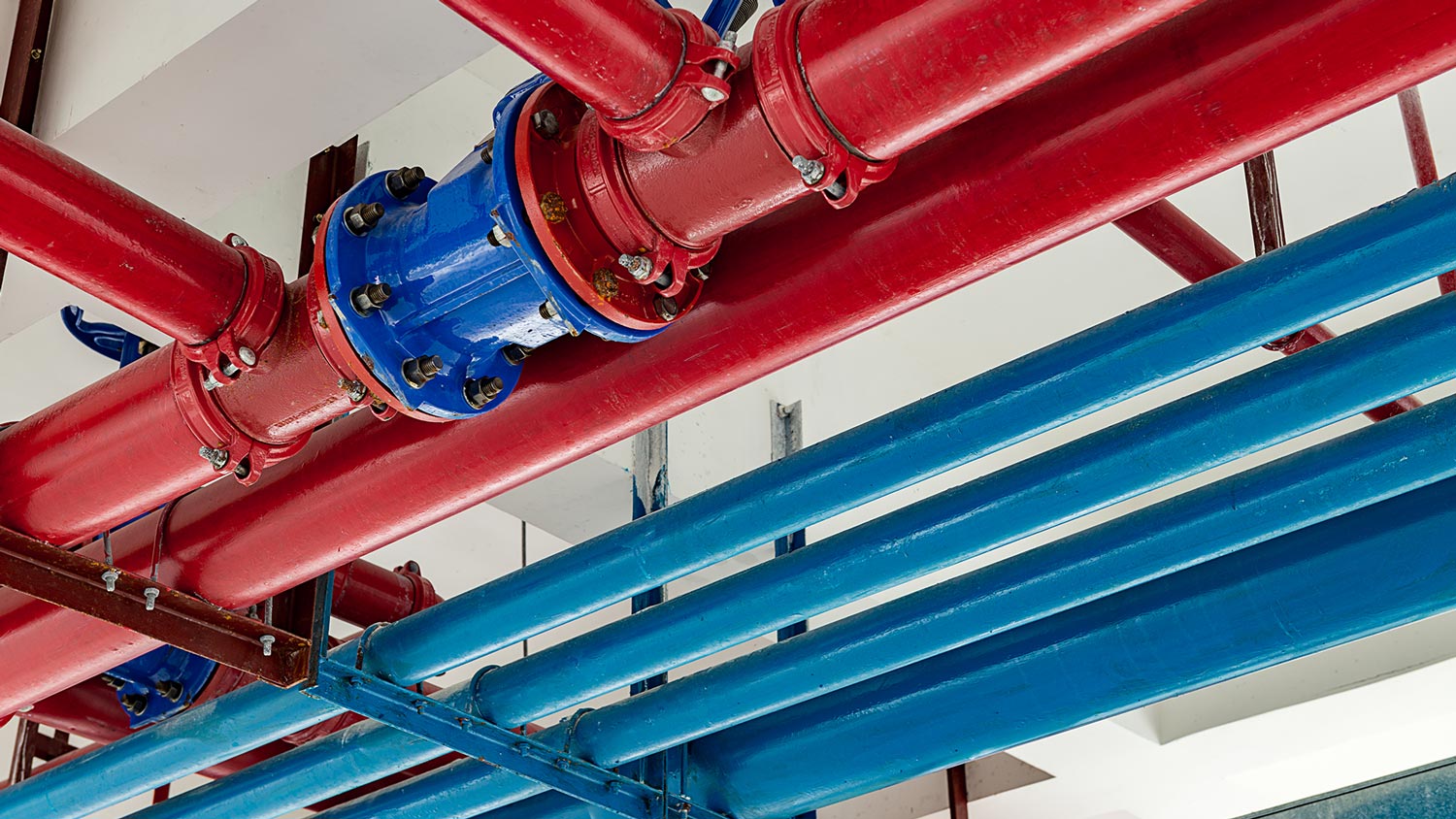 Color-coded red and blue industrial pipes in a commercial building
