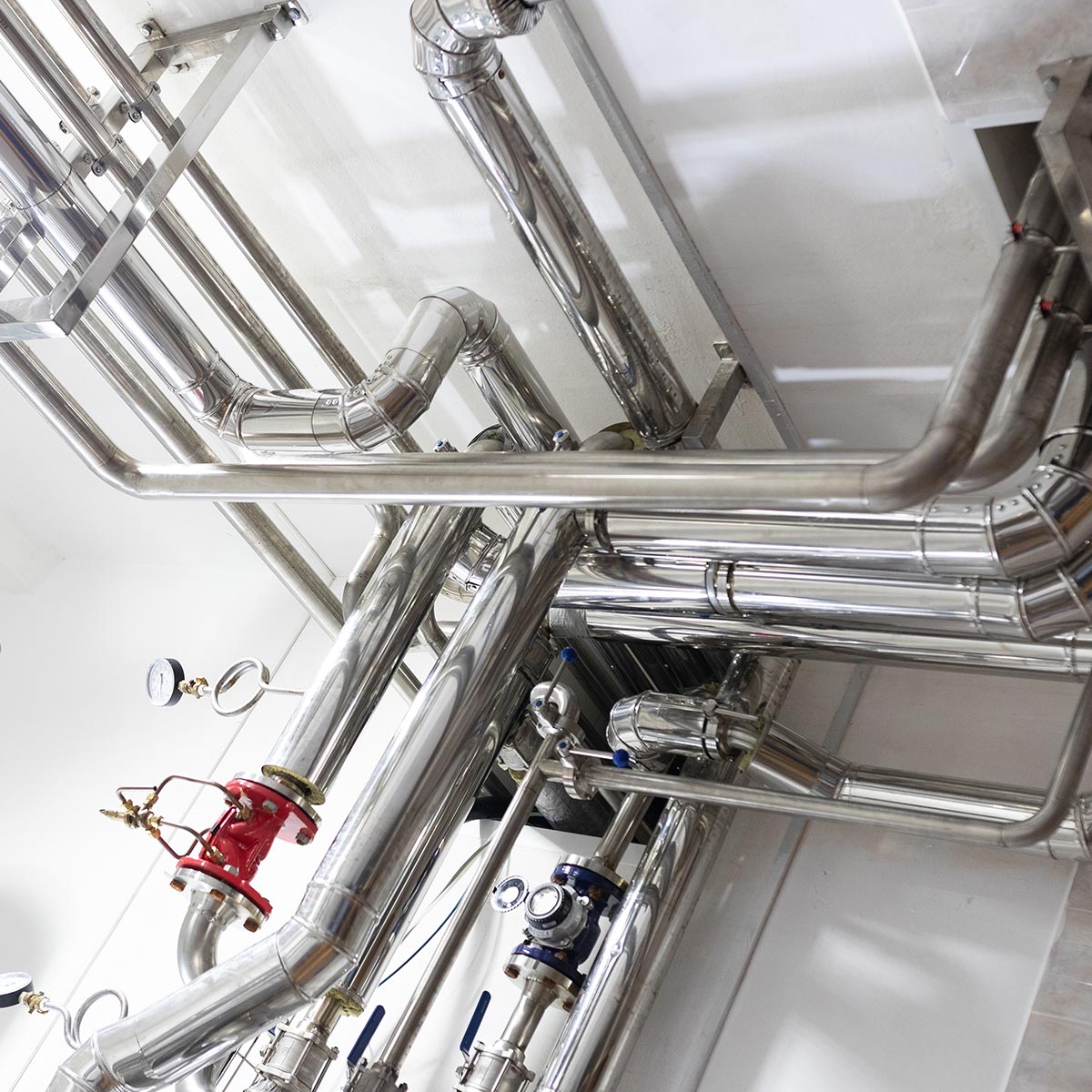 Stainless steel commercial plumbing system with valves, gauges, and precision-installed piping
