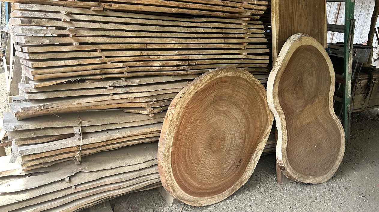 Cuts of raw-edge wood stacked in a shop.