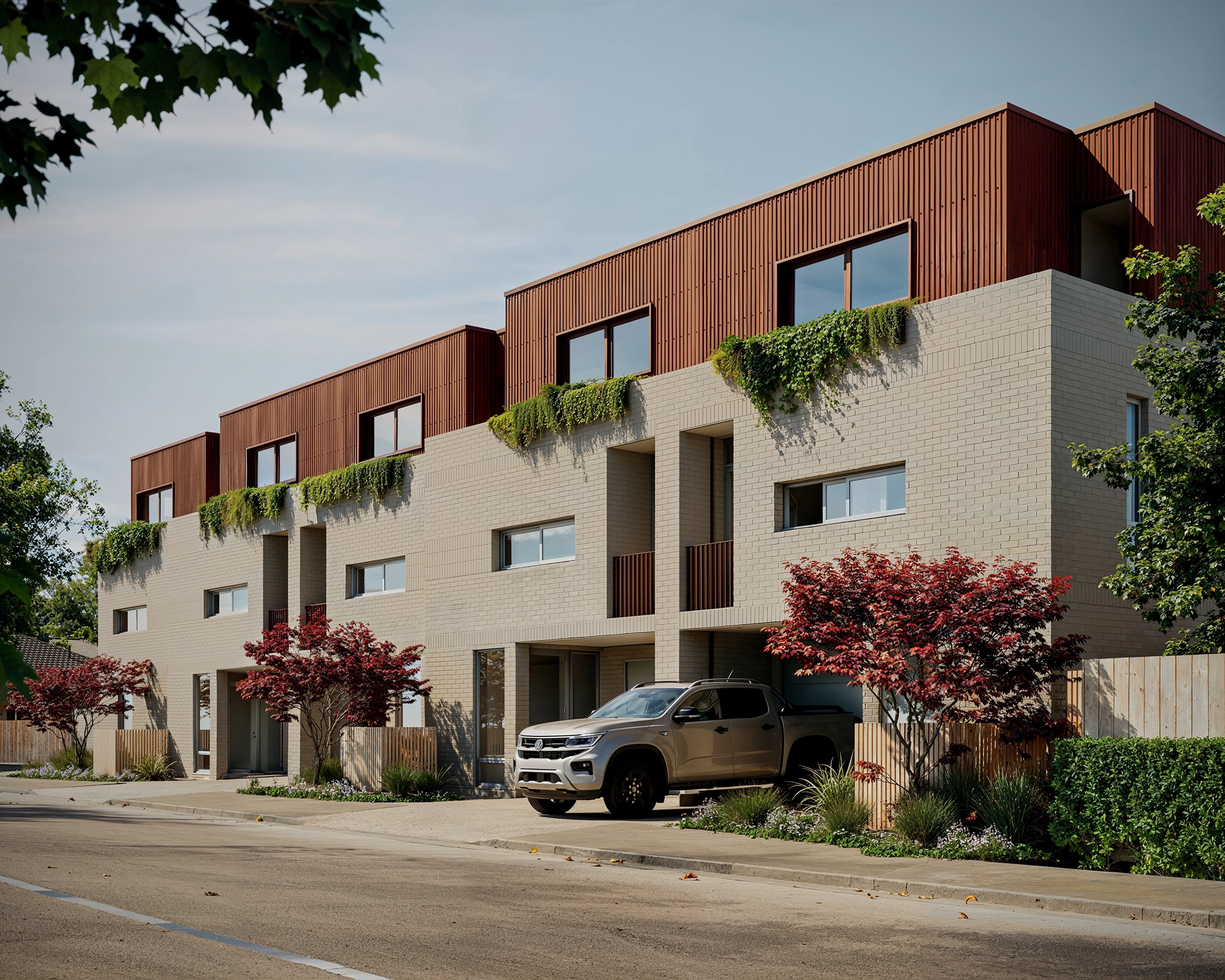 Modern townhouses with beige brick lower floors, brown upper cladding, greenery, and parked truck in driveway.