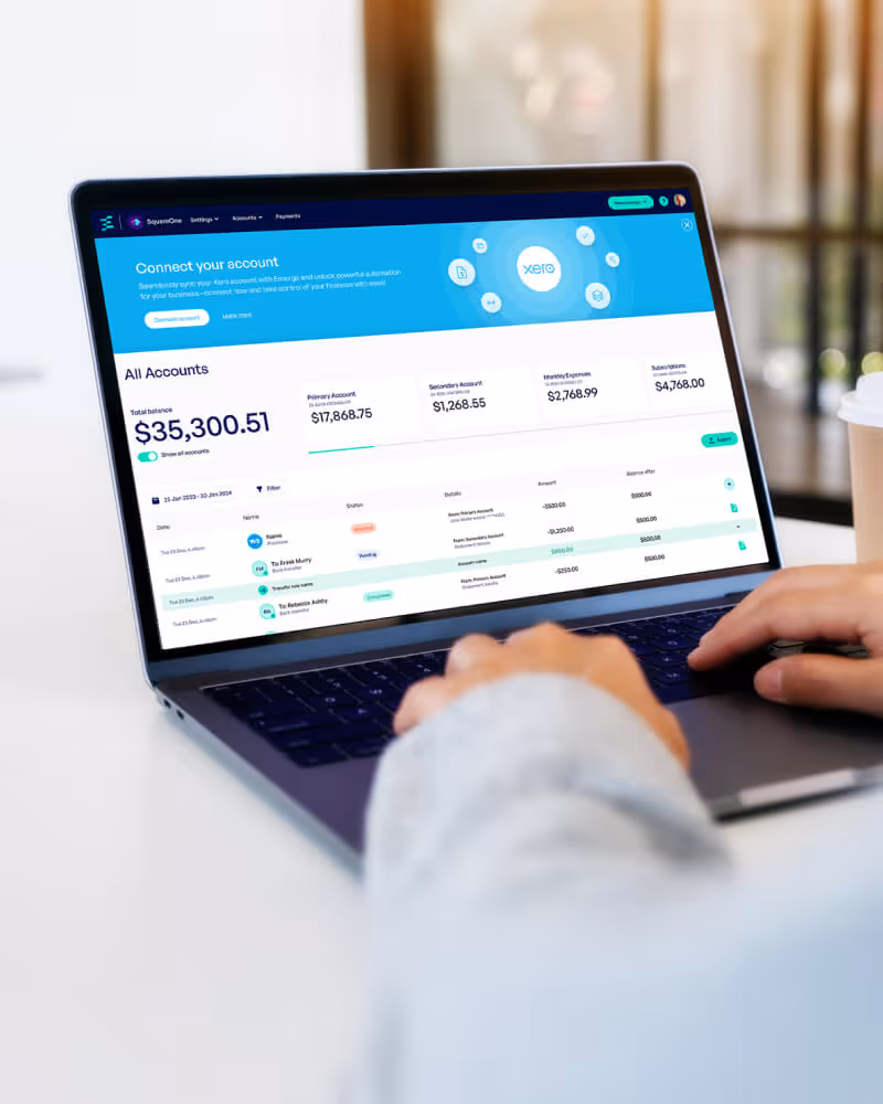 User working on a laptop displaying Xero Emerge financial dashboard with account balances and transaction details.