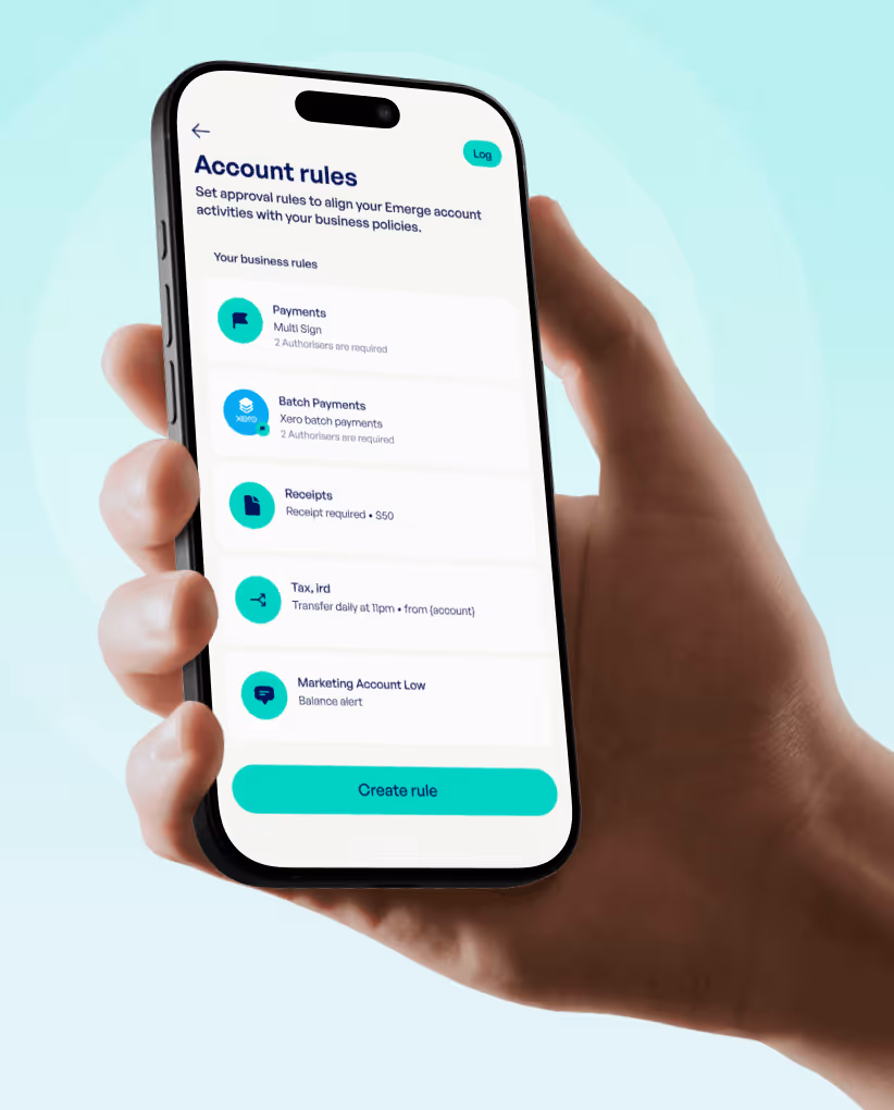 Hand holding smartphone showing account rules screen with options for payments, batch payments, receipts, tax transfer, and marketing account alerts, and a 'Create rule' button.