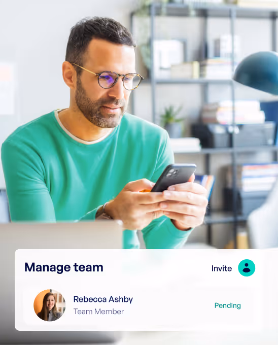 Man wearing glasses and a green sweater looking at his smartphone in a bright office with shelves in the background, next to a digital interface showing team management with member Rebecca Ashby marked as pending.