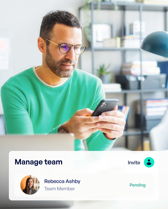 Man wearing glasses and a green sweater looking at his smartphone in a bright office with shelves in the background, next to a digital interface showing team management with member Rebecca Ashby marked as pending.