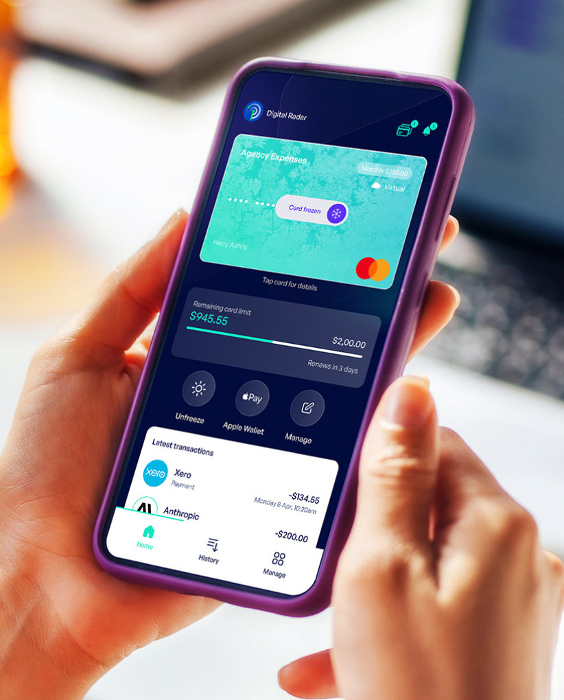 Hand holding a smartphone showing a finance app with a frozen virtual Mastercard, remaining card limit, and recent transactions.