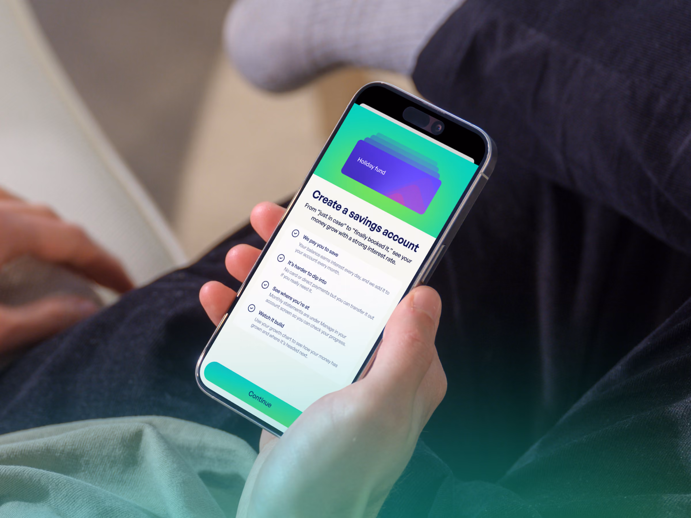 Person holding phone showing app screen to create a savings account with benefits listed.