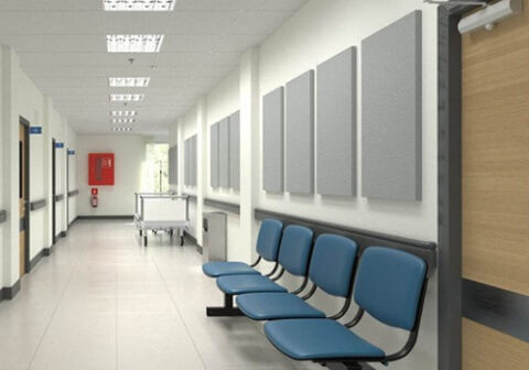 A hospital hall with chairs and above them are acoustic pads.