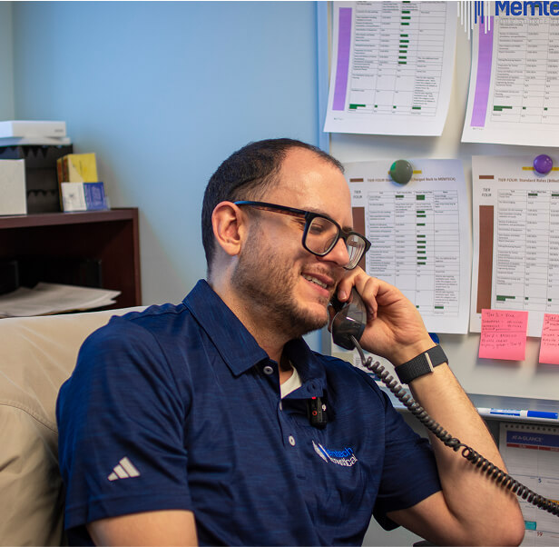 An employee of Memtech Acoustical talking someone over the phone inside his office.