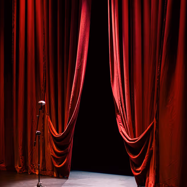 Red curtains on the side in an empty stage.