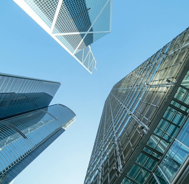 A high shot of three tall buildings from the ground.