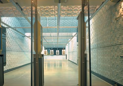 Indoor shooting range with individual target lanes viewed from behind the entry doors.